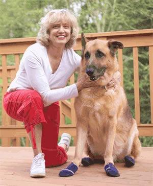 Terri Entler, founder of Healers PetCare, with her dog Jake wearing Healers Medical Dog Boots — the product that inspired the company's founding in 2011